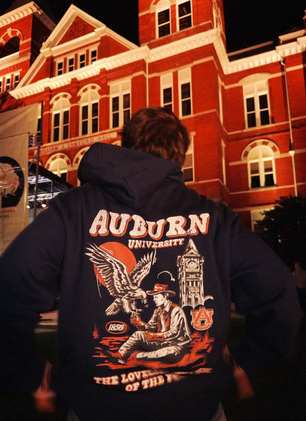 Auburn University Western Collection Hoodie in navy, in front of Samford Hall at night